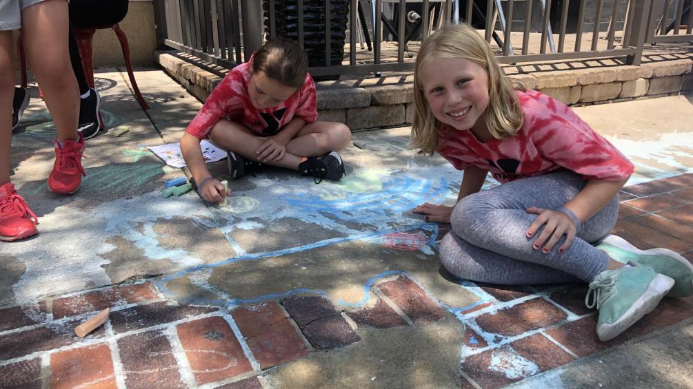 kids drawing on sidewalks with chalk for the flood control stroll