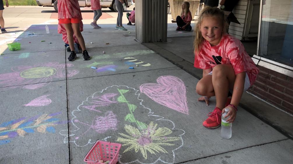 young girl showing chalk art drawing at the flood control stroll