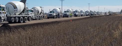 line of cement trucks on rural road